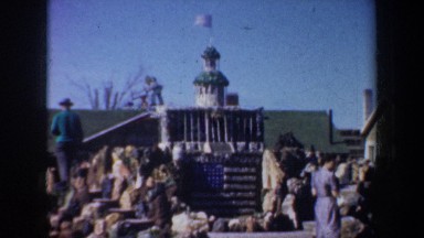 1957: a group of visitors to a miniature town constructed from pebbles, shells