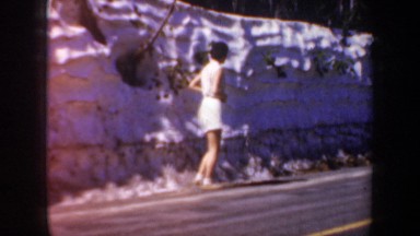 1957: woman walking on road adjacent to snow bank OREGON