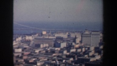 1957: aerial of city blocks with homes, industrial, streets and highways and a