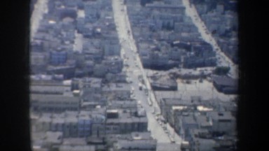 1957: aerial view of san francisco that pans to the golden gate bridge and