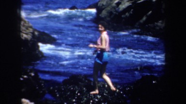 1957: woman walking on slippery rocks. SAN FRANCISCO CALIFORNIA