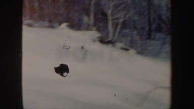 1962: a person with professional-looking skills snowboards down a slope of snow