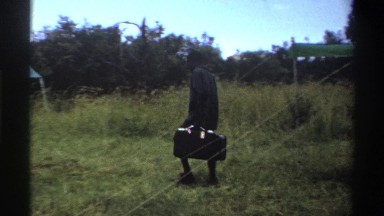1969: men carrying suitcases into between tents NIGERIA