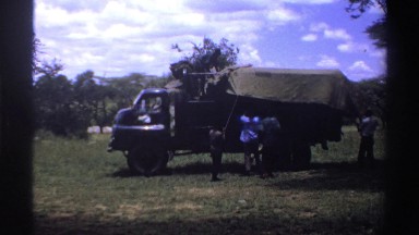 1969: men covering a two ton vehicle with a tarp NIGERIA