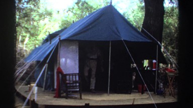 1969: Man Walking Out of Tent on Platform in Forest Area Sudan