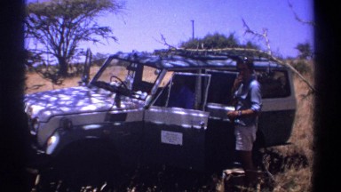 1969: Passenger Speaks to Standing Man Drinking by Open Jeep Doors Parked by