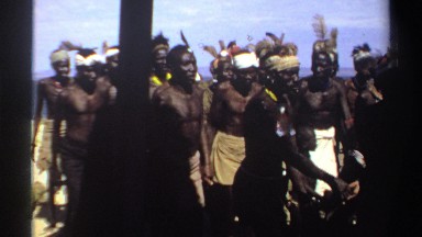 1969: aboriginals of dark skin sing and dance in a sandy area near the sea SUDAN
