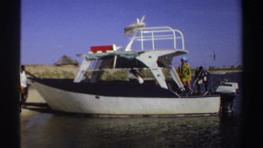 1969: two men and a woman searching on a boat and other two men outside the
