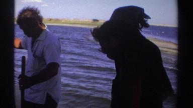1969: small group of people fishing in the open water on a not so sunny day
