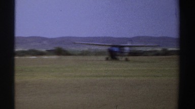 1969: cessna aircraft rolling from grassy parking lane to a semi-improved
