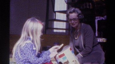 1975: woman and child taking pieces out of a container, looking at the pieces
