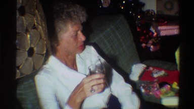 1975: old grand mom sitting in the couch and watching her grandson FLORIDA
