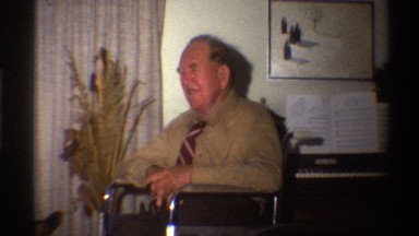 1975: older woman holds drink and looks at her hand near elderly man in