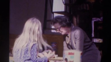 1975: Grandmother Taking Something from Can and Placing Before Girl