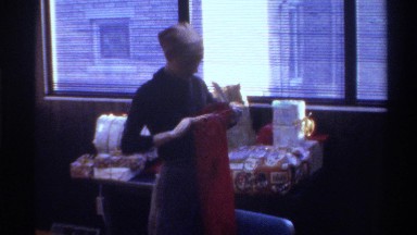 1975: woman pulls item out of a bright red bag. FLORIDA