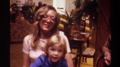 1975: small children and two moms posing for the camera while the kids play with