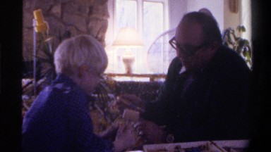 1975: adult showing a child how to use the toy tools, including the hammer
