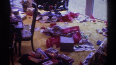 1975: a living room filled with strewn wrapping paper and presents, with a