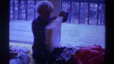 1975: kid opening a box with paper in it and others doing the same FLORIDA