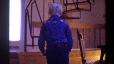 1975: a young boy stacks boxes and his toys, and then falls to the side and the