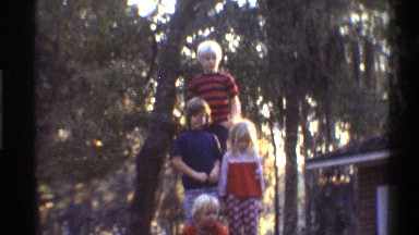 1975: four children posing for a photo and suddenly running back to house.