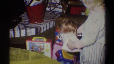 1973: young girl carries doll and plays with toy television in front of working