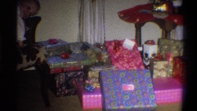 1973: lots of christmas presents surrounding a christmas tree that is elevated