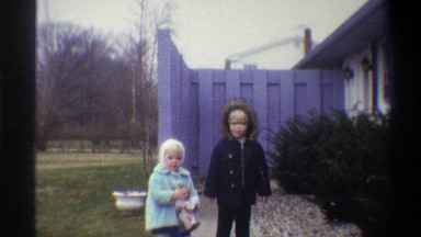 1973: two blonde children standing in front of a purple fence NEW YORK