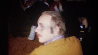 1973: young man with long hair, sideburns and moustache turns head away from