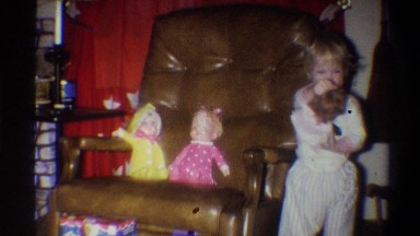 1973: a girl playing with a doll and smiling NEW YORK