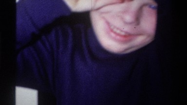 1973: a small smiling child hiding his eyes and talking to a camera NEW YORK