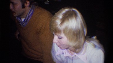 1973: adults having coffee at a gathering in 70s attire. pans out from blonde.
