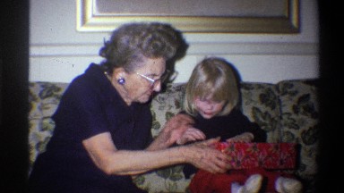 1973: child and grandmother opening the christmas gift packet NEW YORK