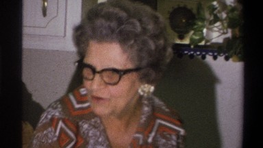 1973: woman speaking to other women at a holiday party, glimpse of a child