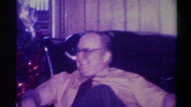 1973: man sitting in chair adjacent to christmas tree talking NEW YORK