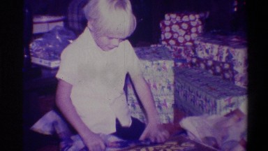 1973: a little boy and a girl tearing off gift wrappers in an excited manner to