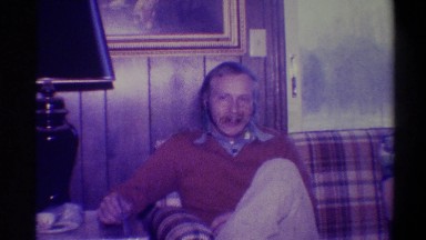 1973: Man Sitting on Couch Talking to Camera; Older Woman with Arms Crossed