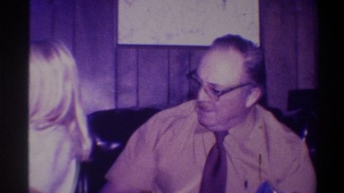1973: Older Seated Man Laughs as Young Girl Twirls by Christmas Tree