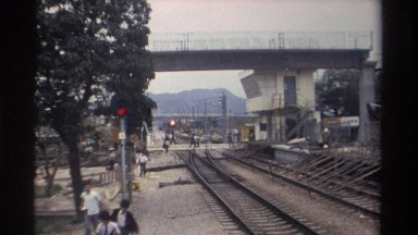 1982: people run and walk away as a train arrives on tracks, coming under a