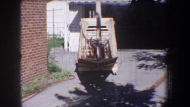 1965: a long hair child plays on a wooden boat shaped artifact VOLMER YUCAIPA