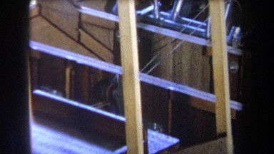 1965: pulley is centered between thin cords extending into large wooden