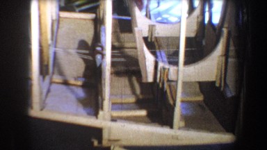 1965: wing-like wooden frame on solid base narrows as it extends outward inside