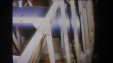 1965: Large Blue Cylinder Reflecting Light Inside Wooden Beam Frame
