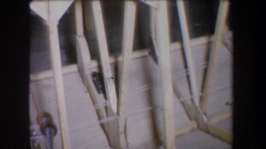 1965: a contraption with wooden poles, with a barrel sitting between them.