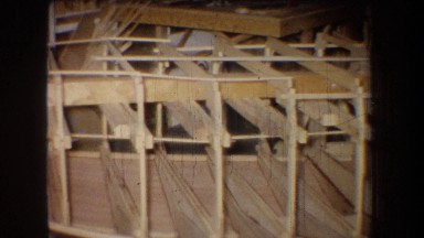 1965: An Unfinished Wooden Structure Viewed From Left To Right In A Dark Interior