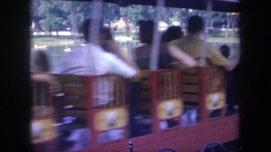 1968: a train full of people going around a big park with a lake MICHIGAN