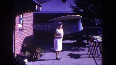 1969: grandma darts inside, excited by the vehicle parked outside on a bright