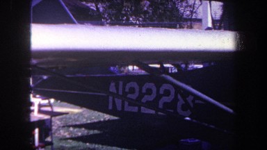 1969: a high-wing, homebuilt airplane sits in a backyard surrounded by shop