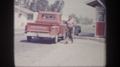 1957: A Man Walks From a Truck to a Car on a Busy Arizona Road