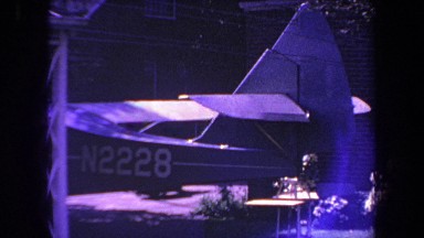 1969: Partial View of a Small Plane Parked in Backyard of House in Volmer